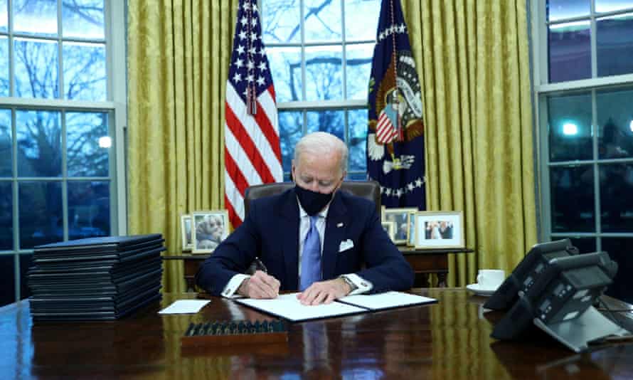 Joe Biden ký các mệnh lệnh điều hành trong Phòng Bầu dục sau khi nhậm chức. Ảnh: Tom Brenner / Reuters